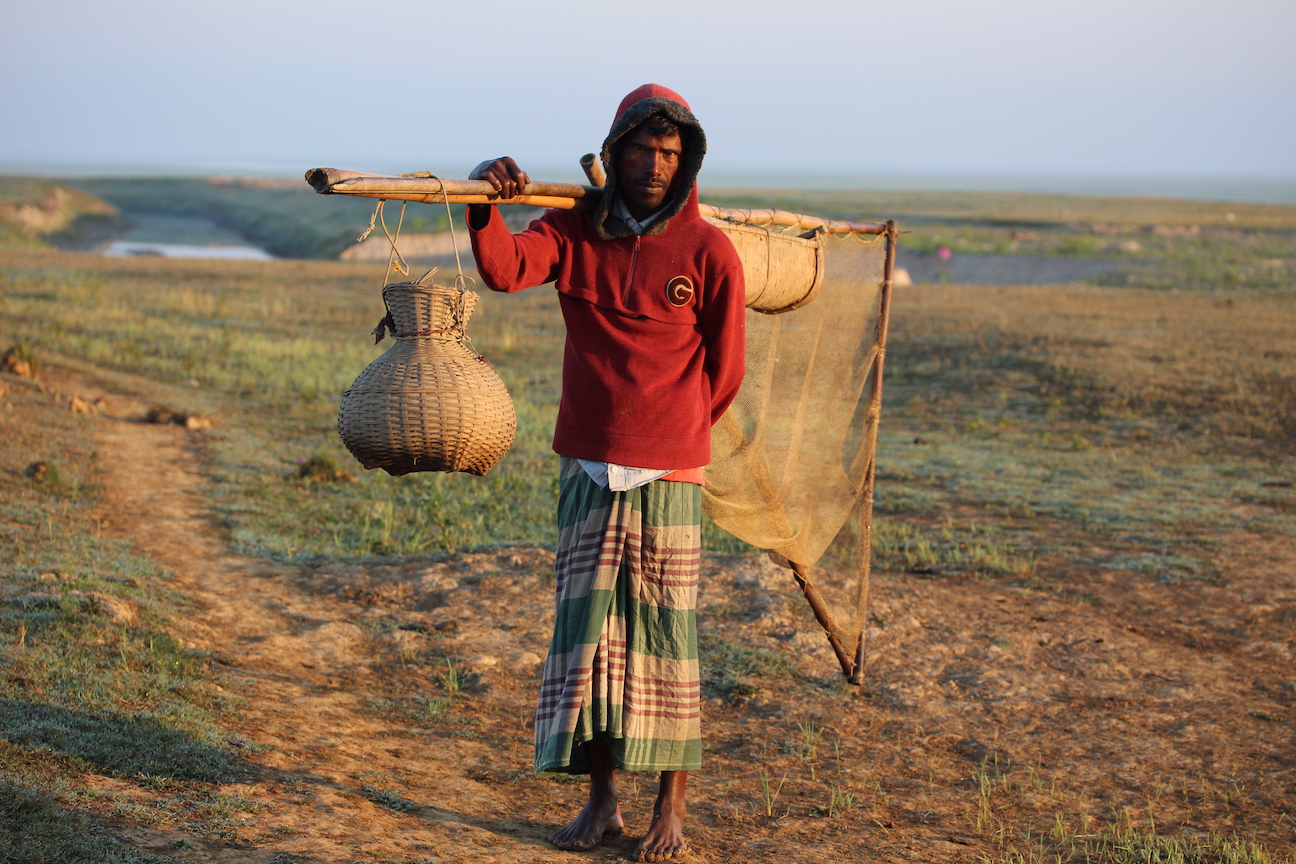 A local fisherman moving for fishing with his puchnet and bamboo basket to Hakluki Haor Wetland