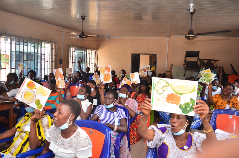 Nutrition training participants hold up signs showing various food groups