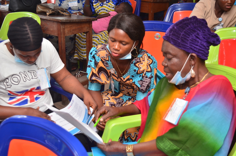 Three women read over training materials