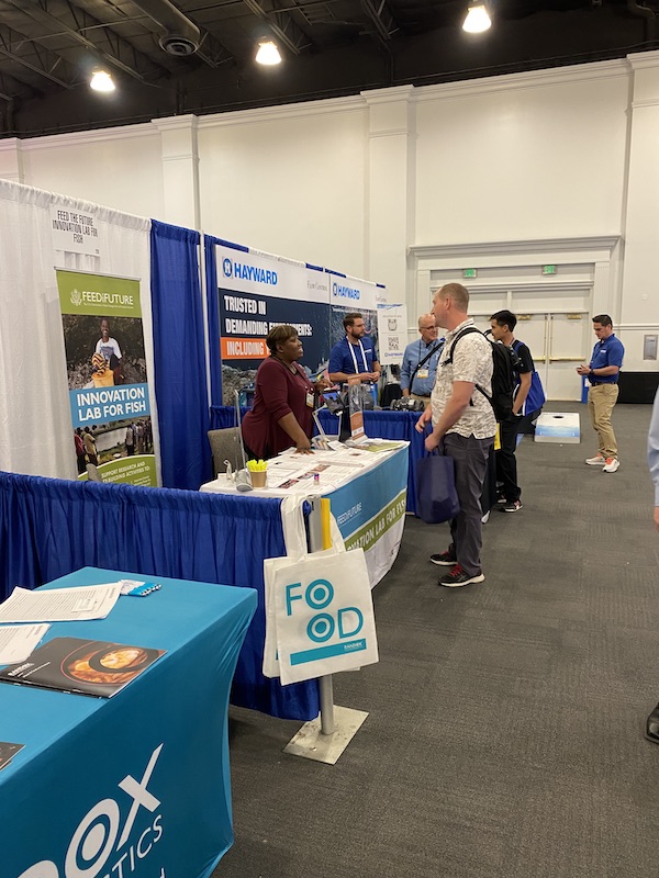 Program and Finance Manager Shauncey Hill talking to conference participants about the Fish Innovation Lab