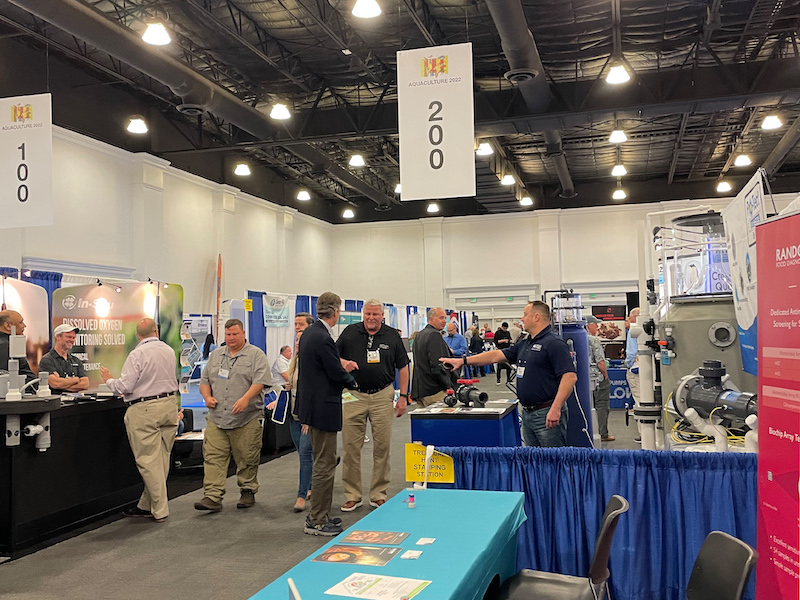 a busy conference hall with several booths